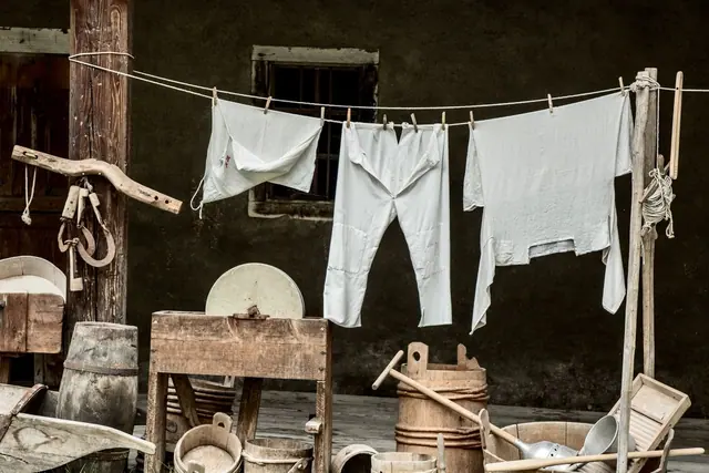 A washing line with white clothes and old laundry tools