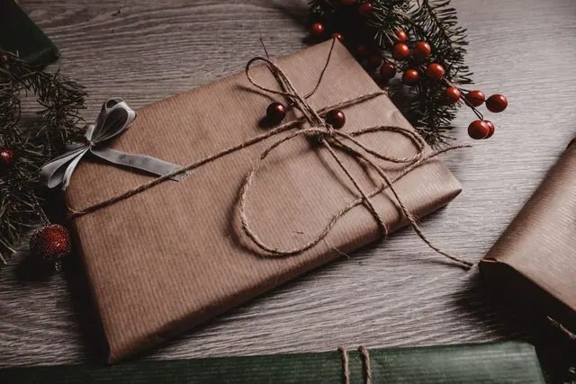Three gift boxes wrapped in brown kraft paper with twine