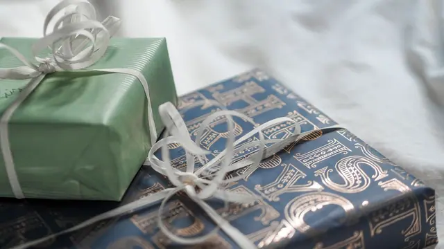 Gift boxes wrapped in green and blue paper with silver ribbon
