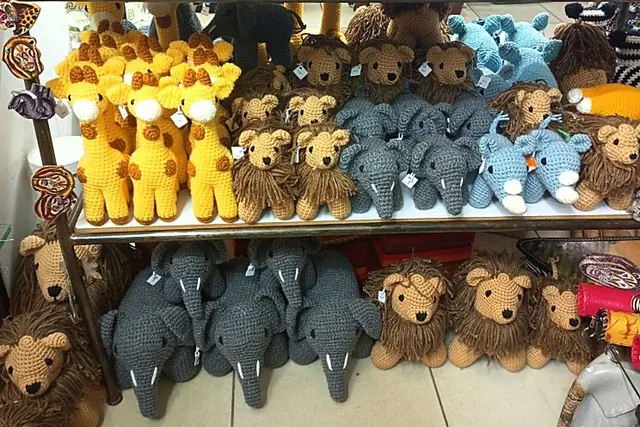 Gift shop shelf with yellow giraffes, lions, grey elephants and light blue rhinos with hang tags