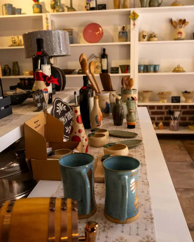 A shop with handmade goods on shelves and a counter