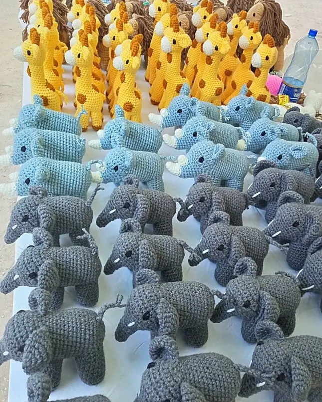 Neat rows of grey elephants and light blue rhinos below a row of yellow giraffes