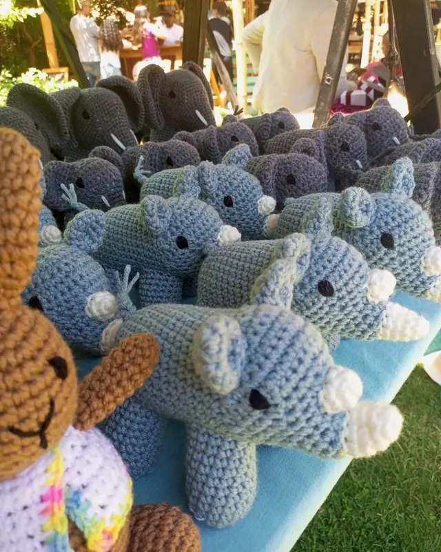 Light blue rhinos and grey elephants on a garden stall with a brown bear at the left