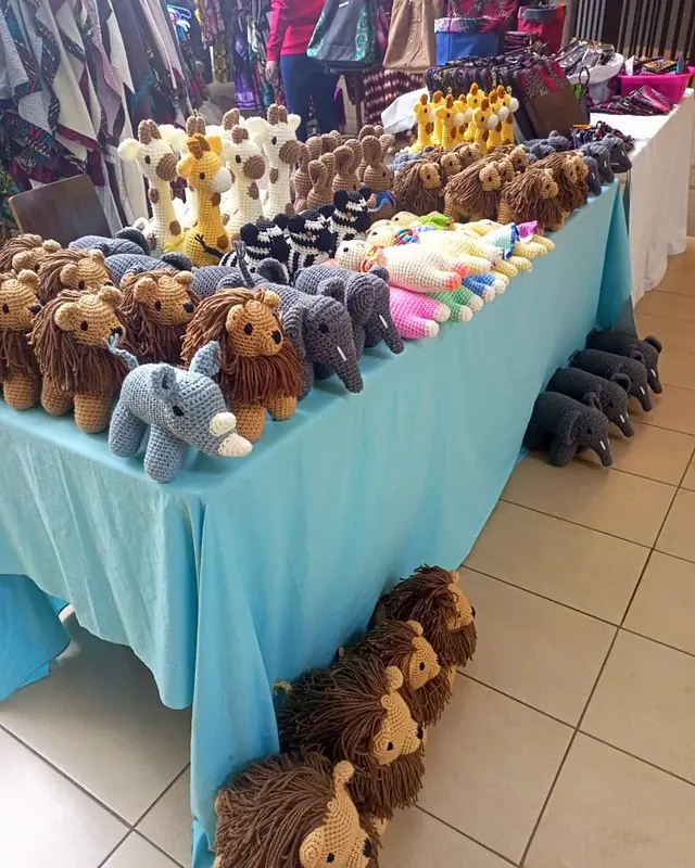 Long table with a turquoise cloth carrying lions, elephants and giraffes in rows