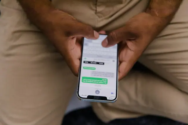 Hands holding a smartphone with a chat conversation, no face