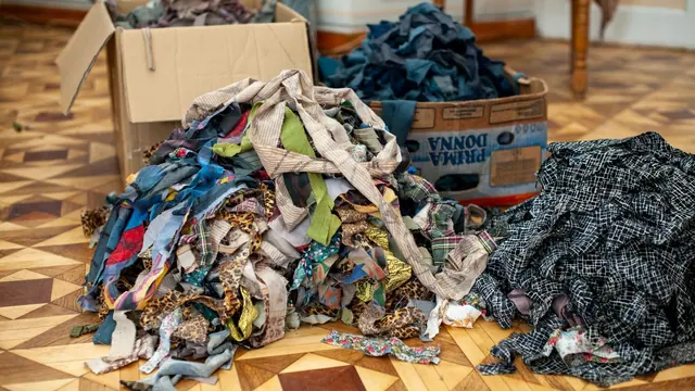 A pile of colourful fabric scraps on a wooden floor