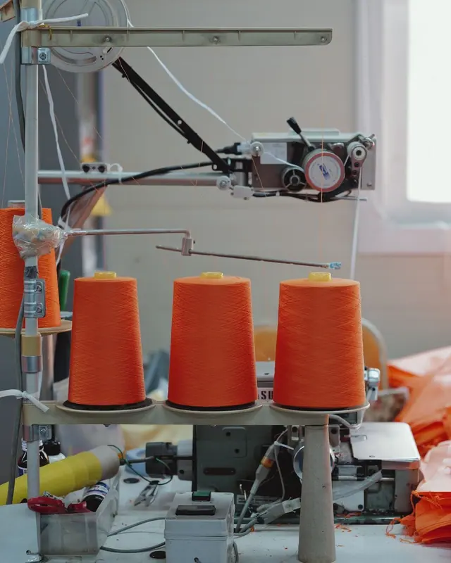 Orange yarn cones on an industrial machine