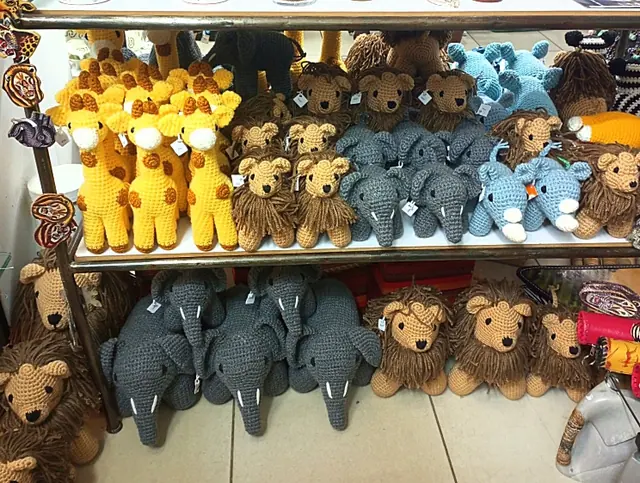 Gift shop shelf with yellow giraffes, lions, grey elephants and light blue rhinos with hang tags