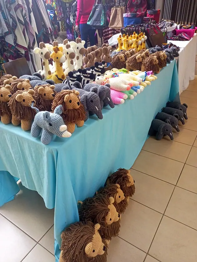 Long table with a turquoise cloth carrying lions, elephants and giraffes in rows
