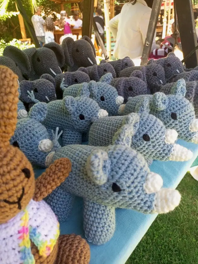 Light blue rhinos and grey elephants on a garden stall with a brown bear at the left