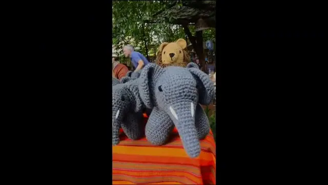 A market stall with crocheted giraffes, elephants and lions, filmed up close